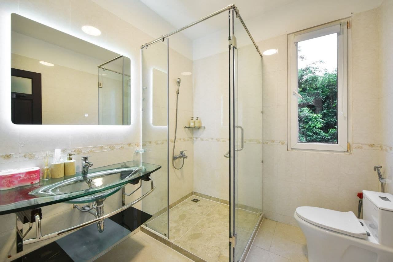 Bathroom with a glass walk-in shower and a lit mirror
