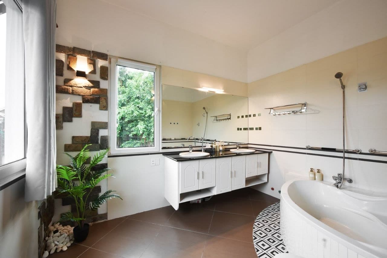 Bathroom with a corner bathtub, stone feature wall and a double vanity