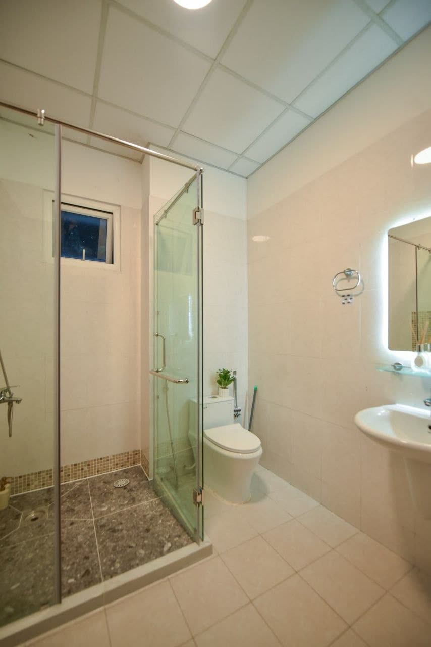 Bathroom with a glass shower cubicle and a lit mirror
